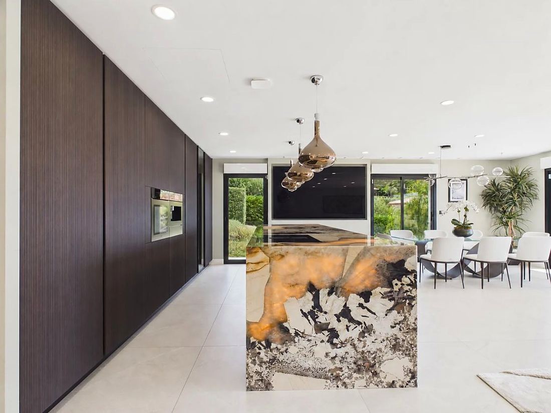 Kitchen with dark timber wall and sculptural stone island