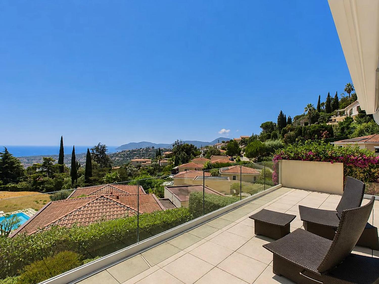 Terrace with glass balustrade looking over rooftops to the Mediterranean