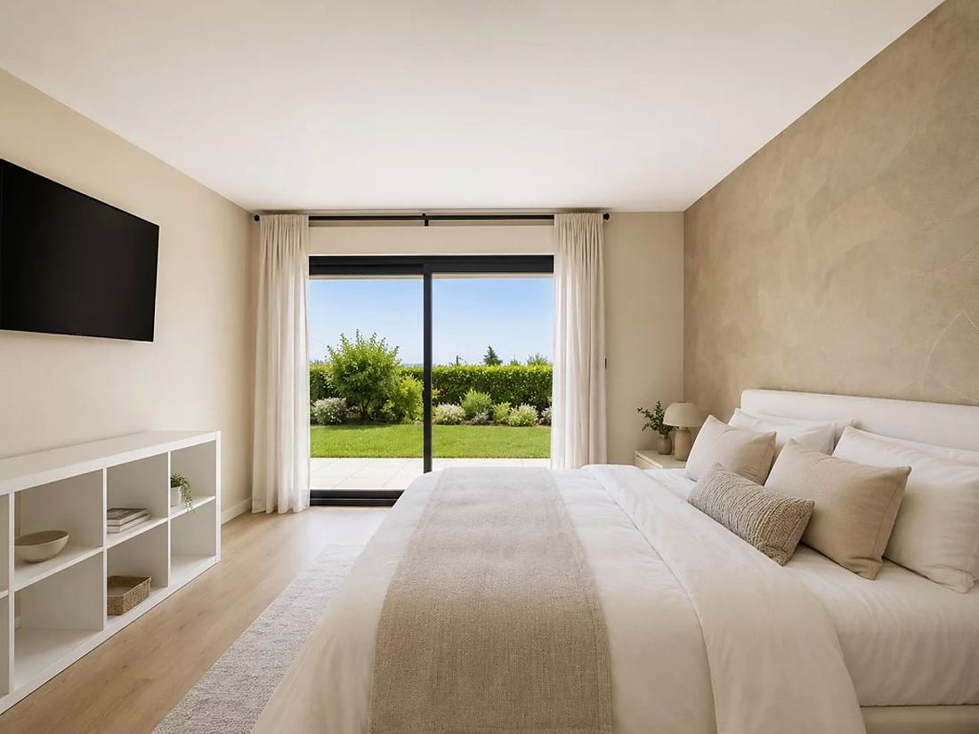 Bedroom in warm neutral tones opening onto the lawn