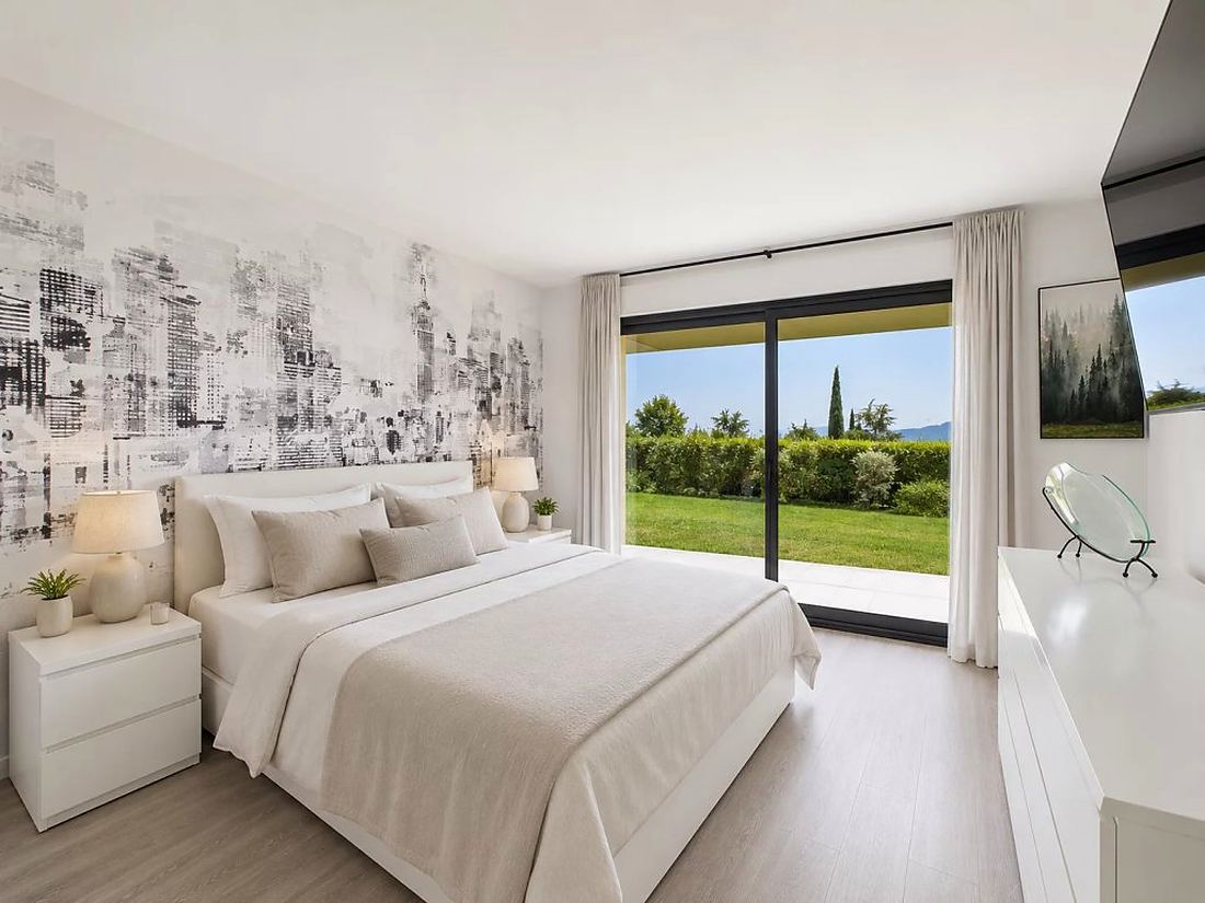 Bedroom with garden access and sea view beyond