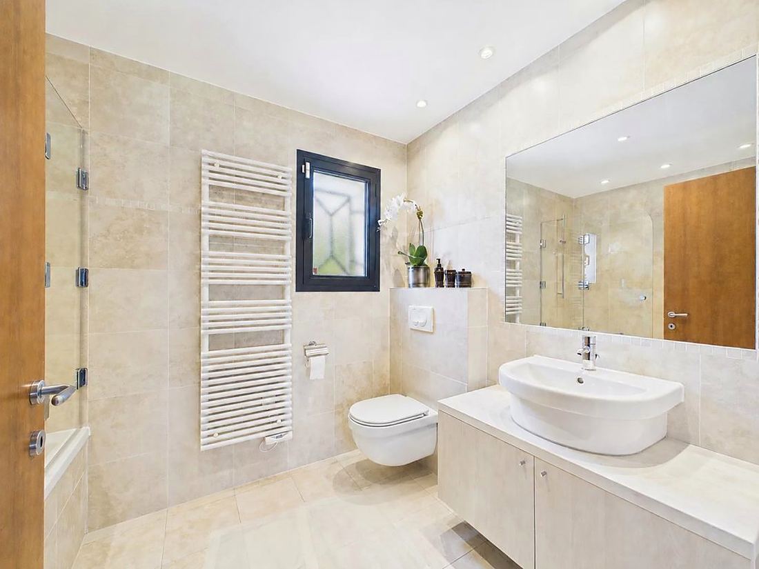 Bathroom in travertine with a large mirror